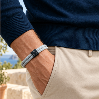 Bracciale con cordino grigio e iniziali incise indossato al polso