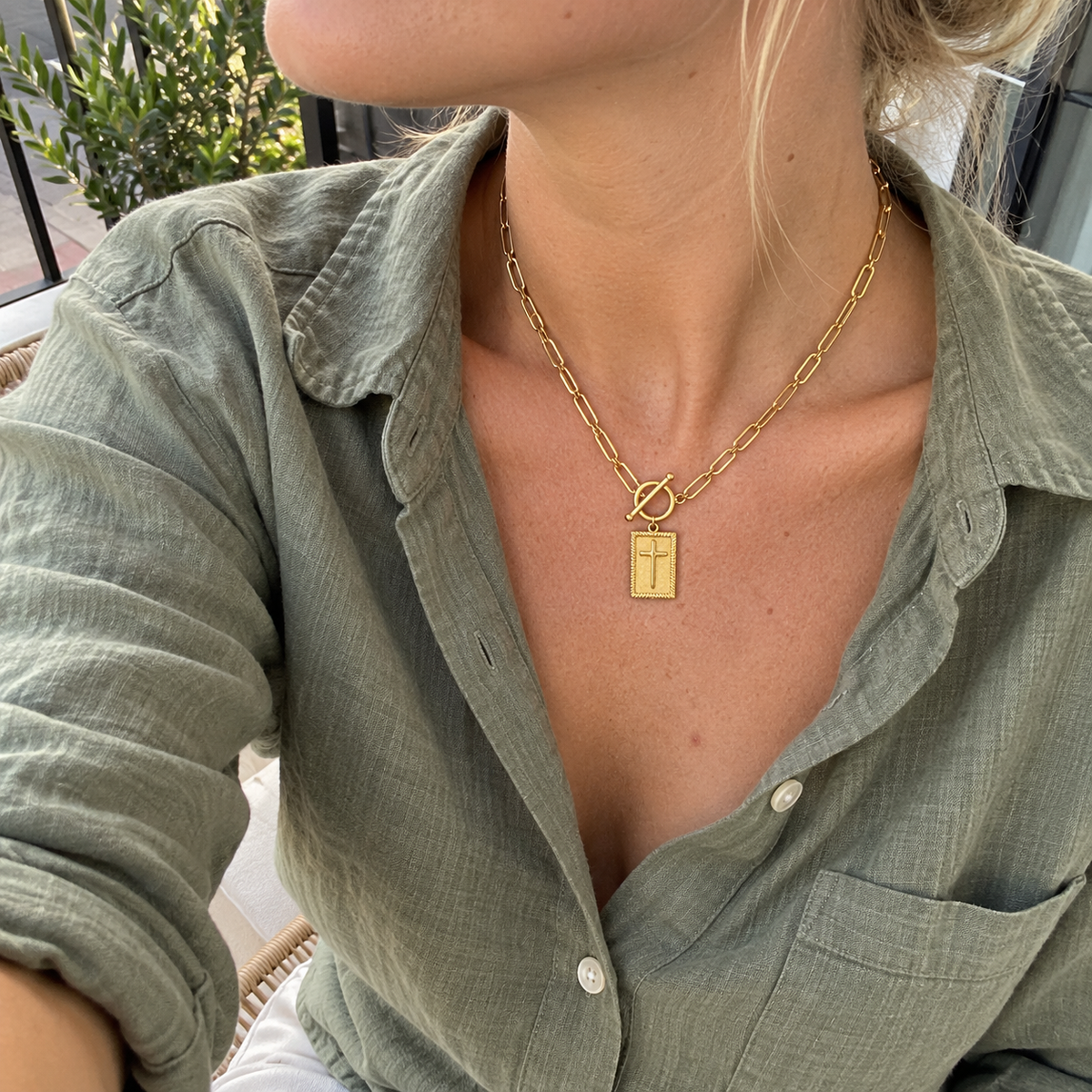 Collana Croce Paperclip, selfie dall’alto con camicia verde