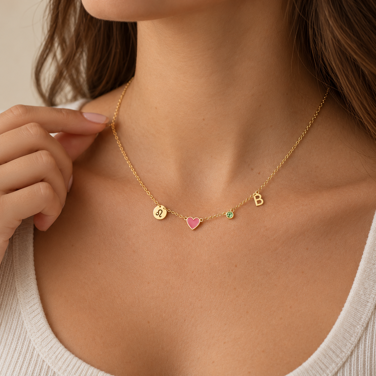 Collana Cuore Norelia dorata con iniziale B, cuore rosa, pietra verde e segno del Leone