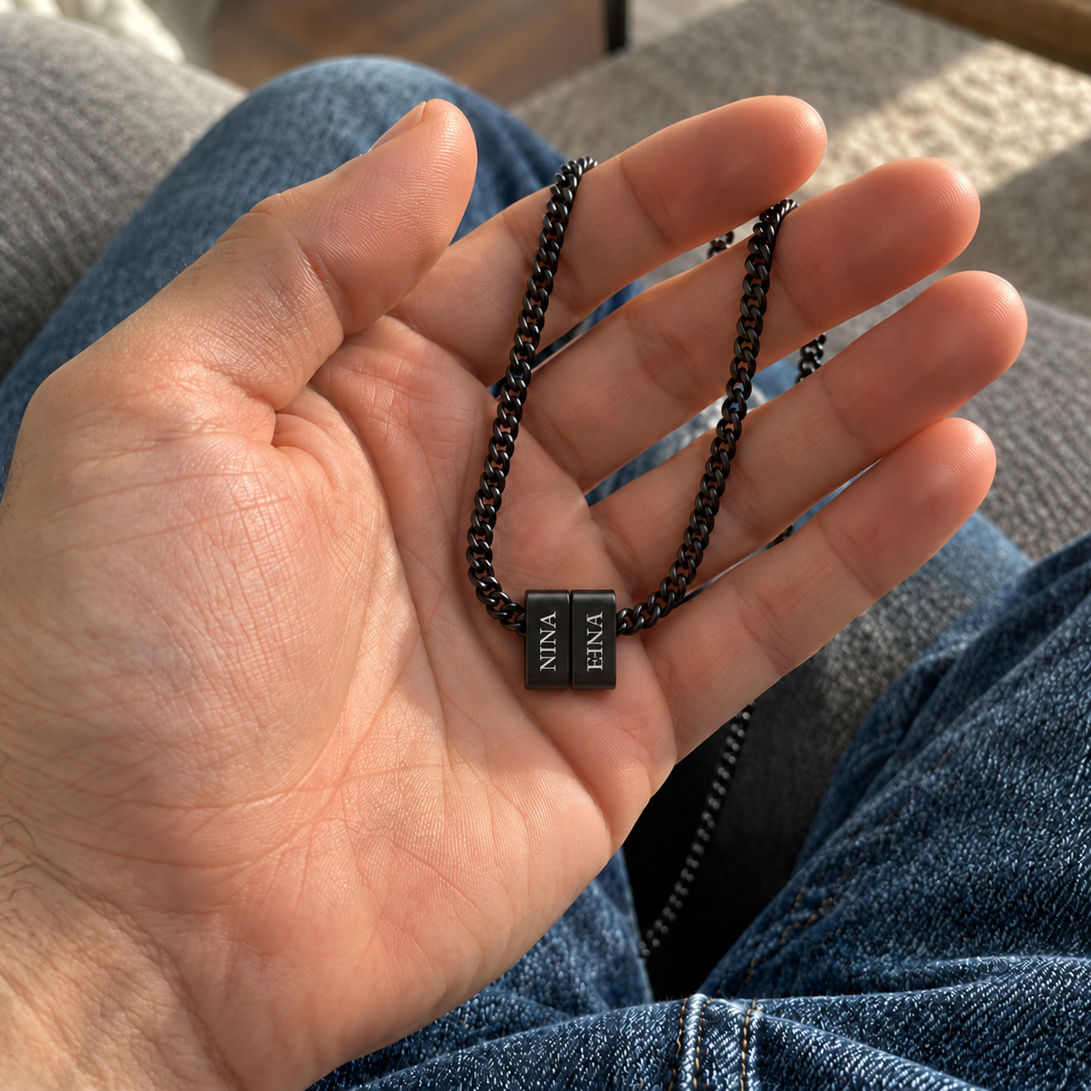 Collana Legami nera con due nomi — dettaglio in mano