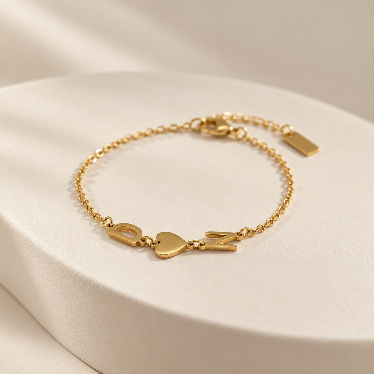 Bracciale Trama dorato — lettere laterali e cuore su fondo avorio