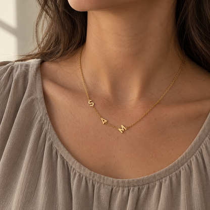 Collana con iniziali laterali S A M indossata con blusa taupe